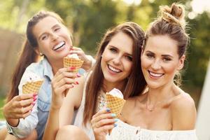 gelukkig groep van vrienden aan het eten ijsje buitenshuis foto