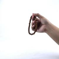 hand- Holding gebed kralen geïsoleerd Aan een wit achtergrond foto