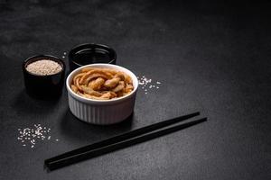 smakelijk pittig Koreaans courgette met specerijen en kruiden Aan een donker beton achtergrond foto