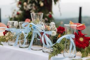 mooi rustiek thema buitenshuis bruiloft of romantisch diner, wit altaar opstelling, bruiloft zand ceremonie vazen gieten glas bekleed omhoog met natuurlijk bloem decoratie. foto