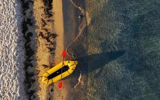 top visie van geel boot dat geparkeerd Aan de kust van oceaan Bij dag foto