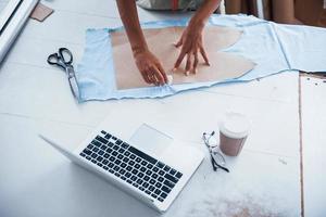 top visie van vrouw arbeider dat is in de naaien fabriek bezig met kleding foto