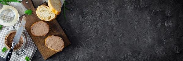 belegd broodje met kip lever paté Aan donker achtergrond. top visie foto