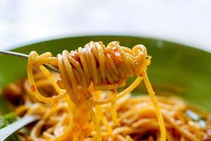 spaghetti met fijngehakt varkensvlees en tomaat saus kijken smakelijk Aan de vork. foto