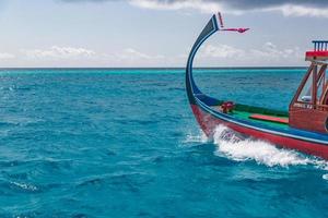 Maldivisch dhoni boot in blauw oceaan achtergrond. Maldiven traditioneel houten boot gebeld dhoni. tropisch zee en houten boot achtergrond foto