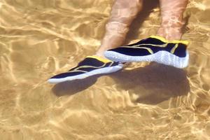 poten in zwemmen schoenen onder water met zon reflectie foto