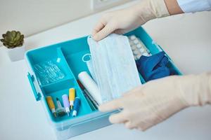 hand- in handschoenen nemen beschermend midicine masker van eerste steun uitrusting foto