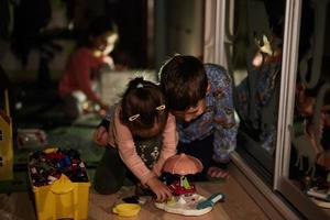 kinderen spelen Bij huis gedurende een Black Out gebruik makend van alternatief verlichting. foto