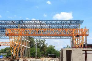 zwaar staal structureel portaal kraan voor in beweging groot platen in een gevaarlijk plaat gieten fabriek is wezen gebouwd sterk en stal tegen een mooi avond lucht achtergrond. foto