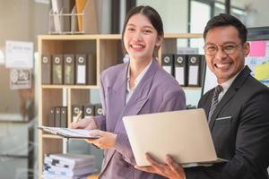 marketing, financieel, boekhouding, planning, twee mannetje en vrouw marketeers gebruik bedrijf documenten en gebruik laptop computers naar Vermelding gegevens naar analyseren bedrijf winsten. foto