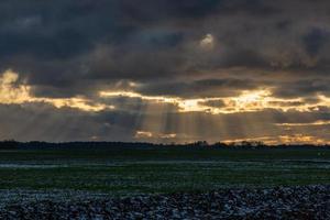 Baltisch zee kust met steentjes en ijs Bij zonsondergang foto