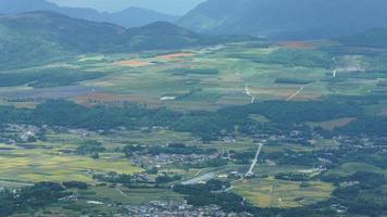 de oogsten geel rijst- veld- visie gelegen in de vallei tussen de bergen met de bewolkt lucht net zo achtergrond foto