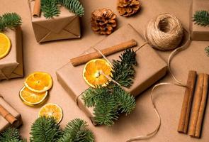 omhulsel cadeaus in ambacht papier en versierd met droog fruit en kaneel stokken.kerstmis en nieuw jaar concept foto