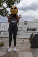 jong vrouw met een pompoen Aan haar hoofd voor halloween, dag van de dood, Mexico foto