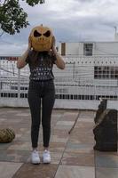 jong vrouw met een pompoen Aan haar hoofd voor halloween, dag van de dood, Mexico foto