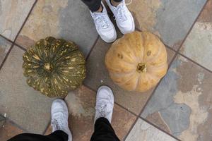 onherkenbaar twee mensen voeten met wit tennis schoenen De volgende naar twee pompoenen, Mexico guadalajara foto