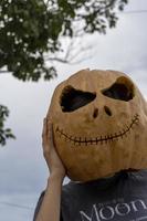 jong vrouw met een pompoen Aan haar hoofd voor halloween, dag van de dood, Mexico foto