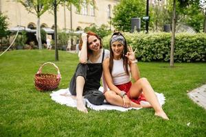 twee Dames hebben picknick samen, zittend Aan de plaid foto