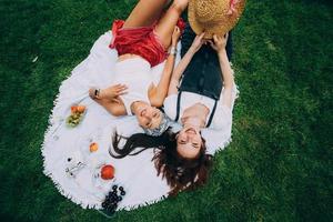 top visie, twee jong Dames aan het liegen in de park foto