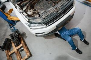 professioneel beroep. werknemer in het blauw gekleurde uniform werkt in de autosalon foto