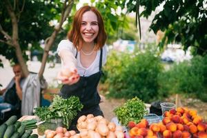 vrouw verkoper Bij de teller met groenten. klein bedrijf concept foto