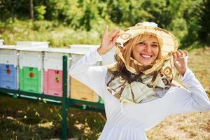 vrouw imker staat tegen netelroos buitenshuis Bij zonnig dag foto