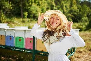 vrouw imker staat tegen netelroos buitenshuis Bij zonnig dag foto