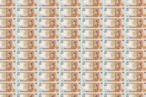 100 oekraïens grivna's rekeningen gedrukt in geld productie transportband. collage van veel rekeningen. concept van valuta devaluatie foto