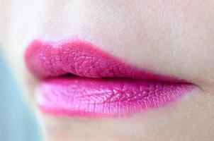 dichtbij omhoog schot van vrouw lippen met glanzend fuchsia lippenstift foto