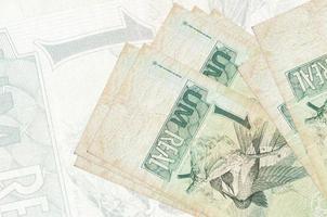 1 braziliaans echt rekeningen leugens in stack Aan achtergrond van groot semi-transparant bankbiljet. abstract presentatie van nationaal valuta foto