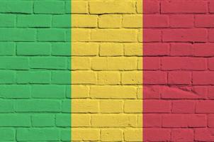 Mali vlag afgebeeld in verf kleuren Aan oud steen muur. getextureerde banier Aan groot steen muur metselwerk achtergrond foto