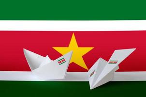 Suriname vlag afgebeeld Aan papier origami vliegtuig en boot. handgemaakt kunsten concept foto