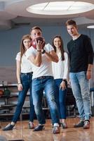 jonge vrolijke vrienden hebben plezier in de bowlingclub in hun weekenden foto