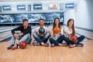 rust nemen. jonge vrolijke vrienden hebben plezier in de bowlingclub in hun weekenden foto