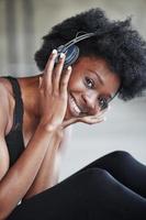 verticale foto. portret van Afro-Amerikaans meisje in fitnesskleren met een pauze na de training foto