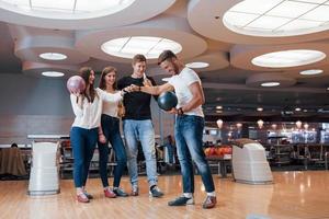 leuk spel. jonge vrolijke vrienden hebben plezier in de bowlingclub in hun weekenden foto