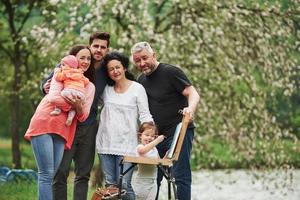 weekend samen doorbrengen. familie hebben goede tijd in het park. jonge schilder die leert tekenen foto