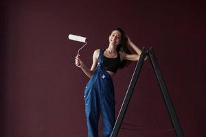 jonge huisvrouw besloot behang in haar nieuwe huis in de kamer te lijmen foto