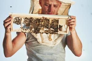 Doorzichtig lucht. imker werken met honingraat vol van bijen buitenshuis Bij zonnig dag foto