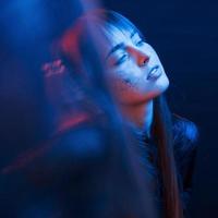 sensualiteit en plezier. studio-opname in donkere studio met neonlicht. portret van een jong meisje foto