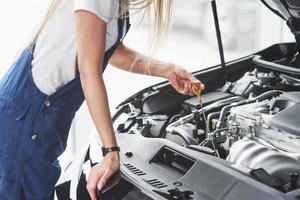 zwaar bouw. auto verslaafd vrouw reparaties zwart auto binnenshuis in garage Bij dag foto