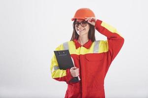 Welkom naar onze werkplek. brunette vrouw in oranje en geel uniform staat tegen wit achtergrond in de studio foto