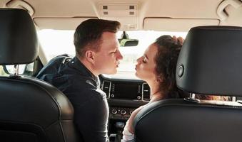 geven een kus. mooi mensen is in de modern auto Bij hun weekends foto