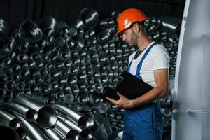 met zwart gekleurde kladblok. Mens in uniform werken Aan de productie. industrieel modern technologie foto