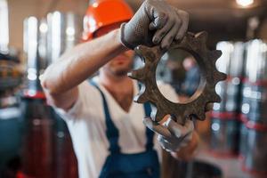 productie van versnellingen. industrieel modern technologie. in beschermend handschoenen foto