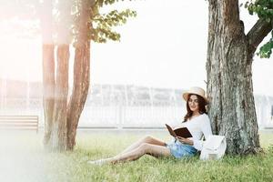 verlichting effect. jong vrouw hebben weekend en zit in de park Bij dag foto