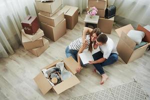 visie van de top. vrolijk jong paar in hun nieuw appartement. opvatting van in beweging foto