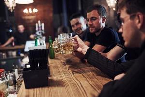 positief mensen. vrienden resting in de kroeg met bier in handen. hebben gesprek foto