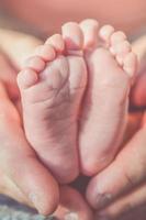 ouder die de voeten van een baby vasthoudt