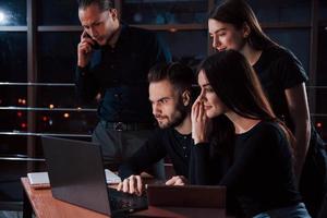 houten tafel. team van jong bedrijf mensen werken Aan hun project Bij nacht tijd in de kantoor foto